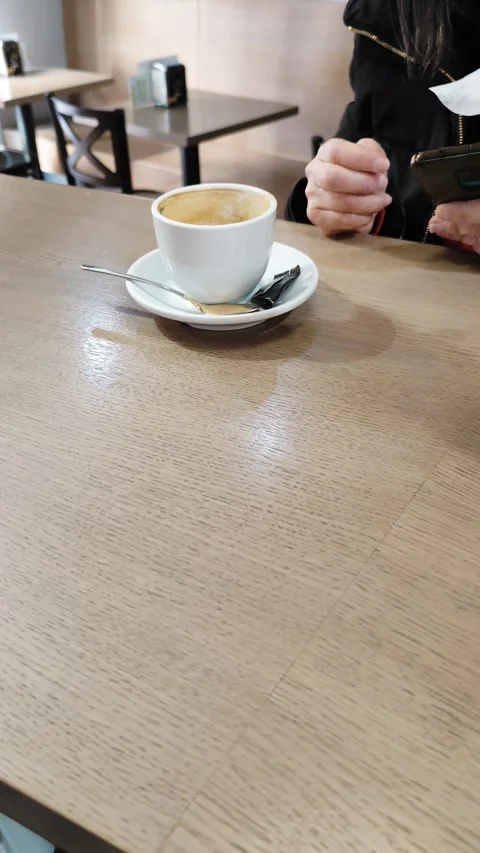 Half Empty Cup of Coffee on a Wooden Table Stock Footage 329386381
