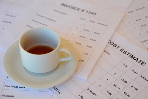 Half empty cup of tea on financial documents Stock Photos