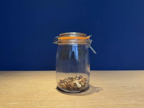 Half empty jar of nuts on blue background Stock Photos