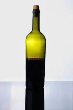 Half empty red wine bottle isolated on white Stock Photos
