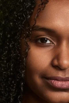 Half face of black curly haired woman Stock Photos