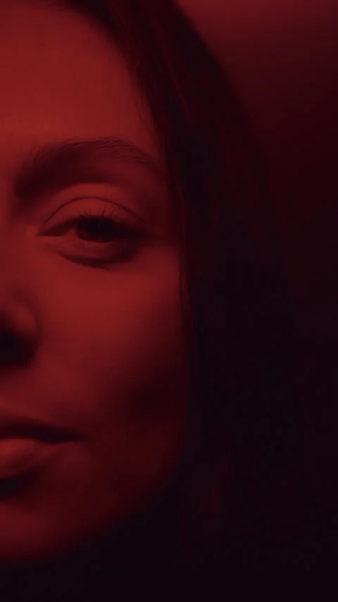 Half Face Portrait of Beautiful Female Model in Dark Red Light Stock Footage 335893260