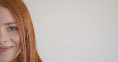 Half face portrait of beautiful ginger model watching smilingly and intently Video stock 107972386