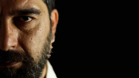 Half face portrait of concentrated bearded man opens his eyes Stock Footage 157486428