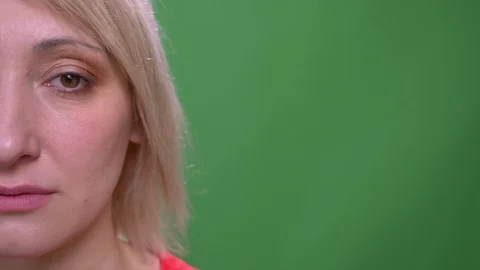 Half face portrait of middle-aged blonde short-haired model watches calmly into Stock Footage 108681749