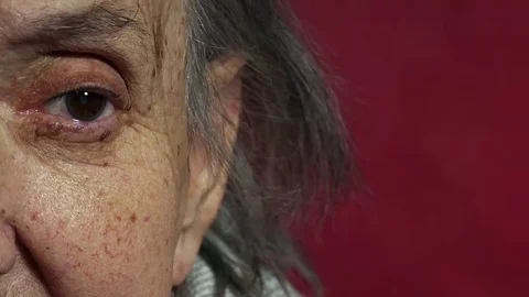Half face portrait of an old wrinkled woman sitting lonely at home  Video stock 69214157