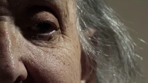 Half face portrait of an old wrinkled woman sitting lonely at home  Video stock 69214500
