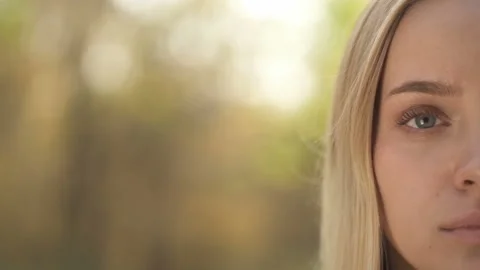 Half face portrait of smiling blonde woman at the nature. Slowmotion. Stock Footage 119329388