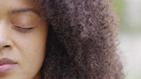 Half face portrait of young black female with her eyes closed in a moment of ser 스톡 동영상 142866462