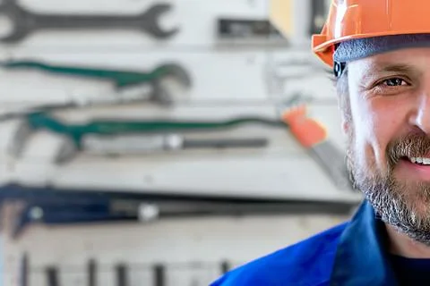 Half the face of a smiling worker in an orange helmet with plenty of copy spa Stock Photos