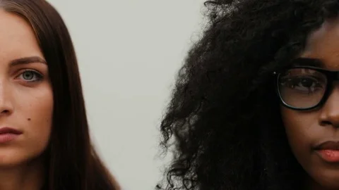 Half faces of two pretty girls on white background. Young attractive couple of Stock Footage 81839625