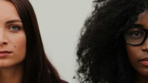 Half faces of two pretty young women on white background. Young attractive Stock Footage 81839668