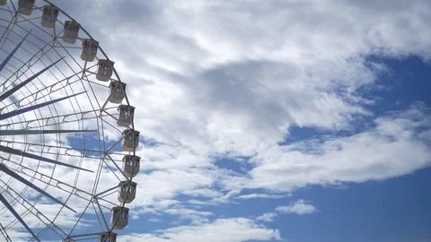 Half Ferris wheel, in front of a blue sky with white clouds, stock photo Stock Photos