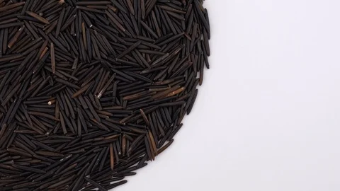 Half frame circle shaped heap of raw wild / black rice rotating on turntable Stock Footage 88633301