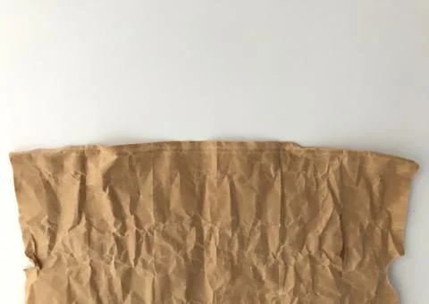 Half frame of light brown crumpled paper and white background Stock Photos