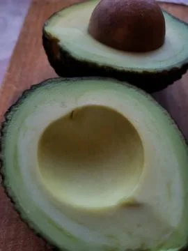 Half of fresh avocado with pit close-up Stock Photos