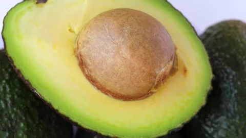 Half a fresh avocado with pit, rotation in circle. cut avocado close-up Stock Footage 281066118