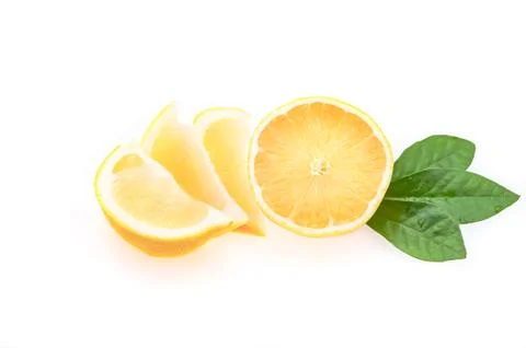 Half a fresh, clean, glowing lemon with green leaves and several cut slices on a Stock Photos