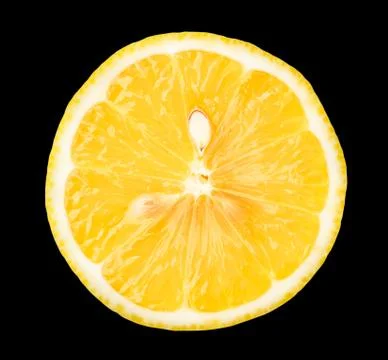 Half a fresh lemon with a bone, isolated on a black background. Stock Photos