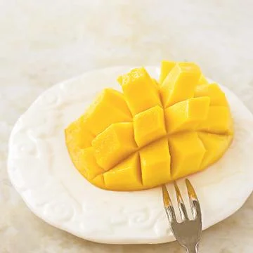 Half Fresh Mango fruit cubes on white Concrete background. Tropical fruit Foto stock