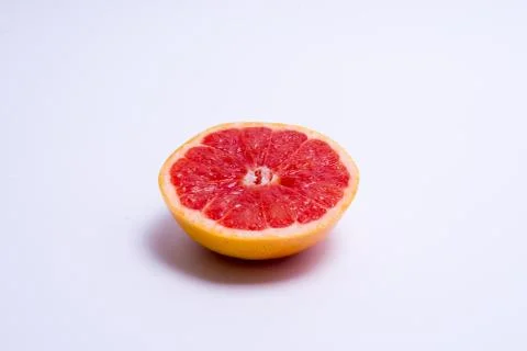 Half a fresh red grapefruit on white background Stock Photos