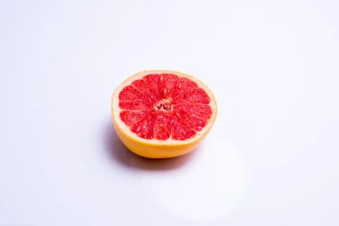 Half a fresh red grapefruit on white background Stock Photos