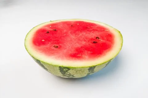 Half a fresh watermelon with bright red flesh on a white background. Stock Photos