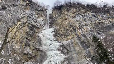 Half-frozen high alpine waterfall in winter ice, Switzerland Stock Footage 284501966