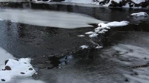 A half frozen river flows slowly in the middle of winter Stock Footage 89307460