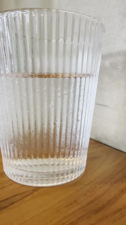 Half Full Water Glass Close Up on Wooden Table Background Video stock 331248374