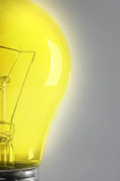 Half glowing light bulb on the gray background. Фото