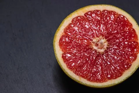 Half of a grapefruit on a black background.  Stock Photos