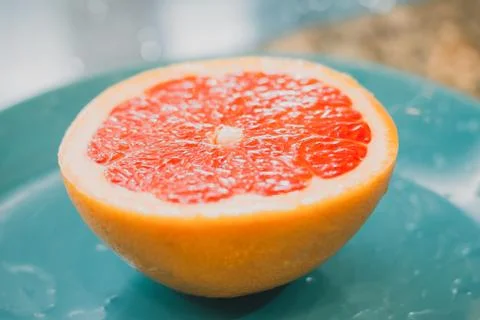 A half of a grapefruit closeup on grey background Stock Photos