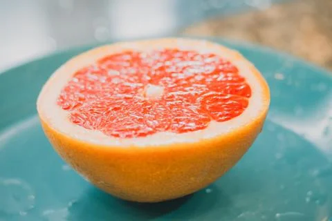 A half of a grapefruit closeup on grey background Stock Photos
