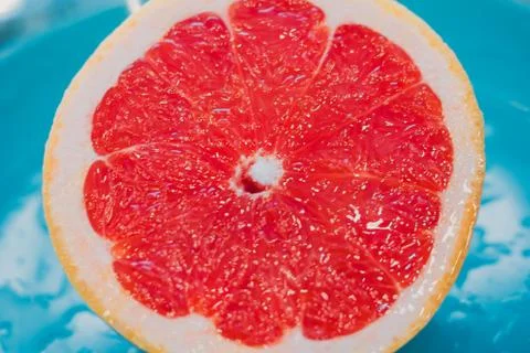 Half of grapefruit isolated on blue background Stock Photos