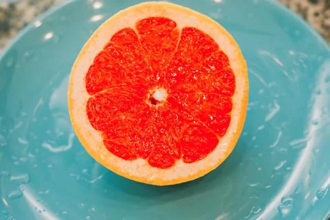 Half of grapefruit isolated on blue background Stock Photos