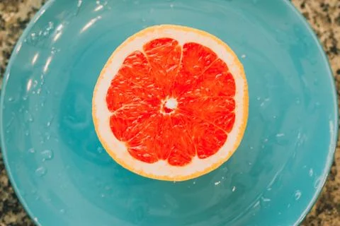 Half of grapefruit isolated on blue background Stock Photos
