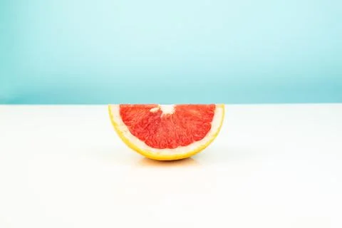 Half of grapefruit on white and blue background Stock Photos