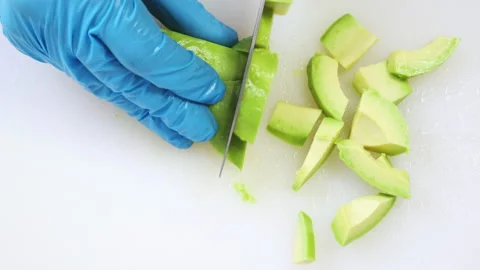 Half of green avocado cutting, chef hands close up Stock-Footage 212705009