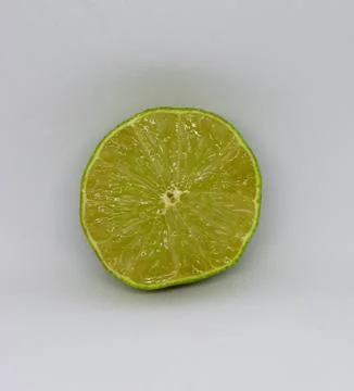 Half a green lime circle on white background isolated Stock Photos