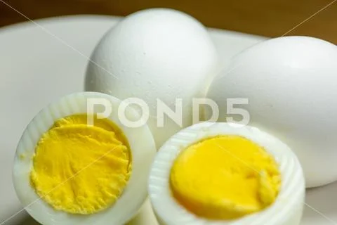 Half a hardboiled egg with the shells laying on the kitchen table Stock Photos