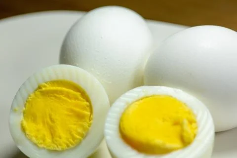 Half a hardboiled egg with the shells laying on the kitchen table Stock Photos