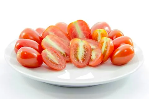 Half ingredient mini tomato sliced on white plate Stock Photos