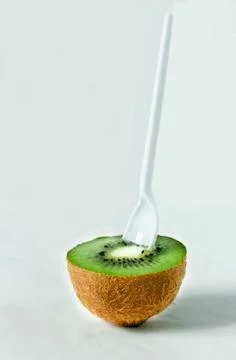 Half a kiwi with a spoon Stock Photos