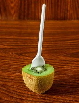 Half a kiwi with a spoon Stock Photos