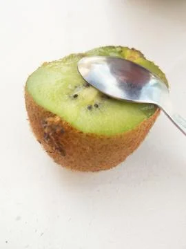 Half a kiwi with a teaspoon Stock Photos