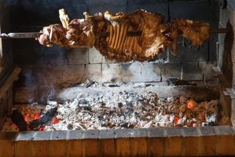 Half lamb barbecue inserted in an iron sword circling above the burning coal Stock Photos