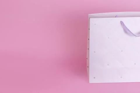 Half of a large light paper bag with ribbon handles is depicted in close-up on a Stock Photos