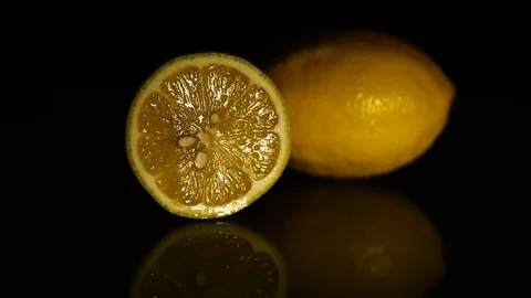 Half a lemon and a whole lemon on a dark table. HD Stock Footage 89762249
