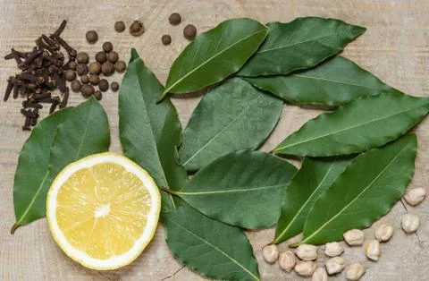 Half a lemon, Bay leaf, spices, lying on the old Board 写真素材